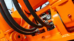 Underside view of hydraulic hoses on an orange colored machine