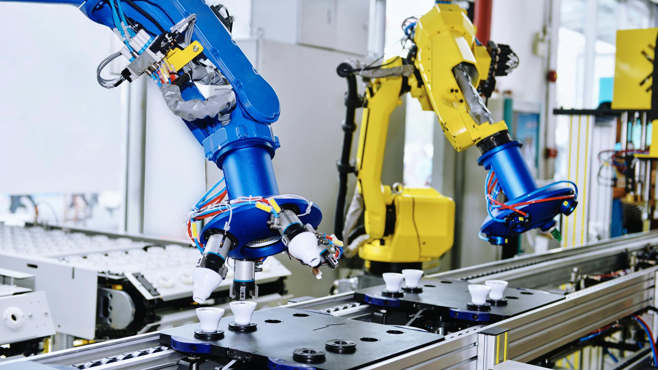 Blue and yellow robots working along a production line