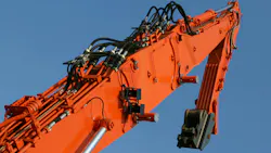 Orange excavator arm with several visible hydraulic components such as hoses