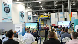 Man standing at podium giving speech to seated crowd in new Bosch Rexroth Industrial Hydraulics warehouse
