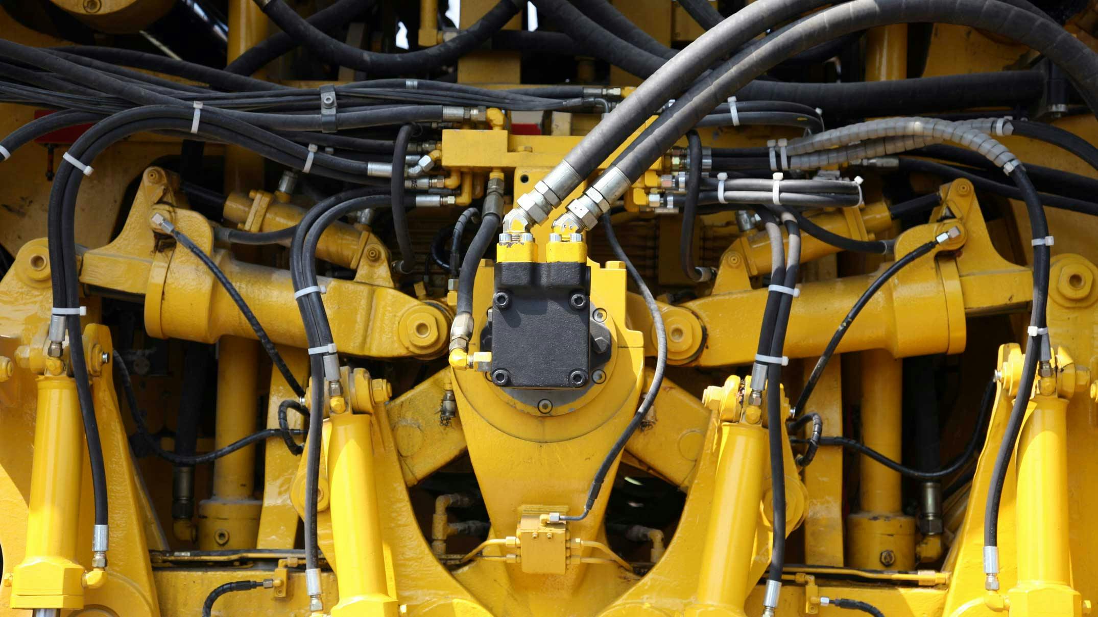 Close Up on Several Hydraulics Components on a Yellow Machine