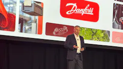 Daniel Winter, president of Danfoss Power Solutions presenting in front of a screen with the Danfoss logo