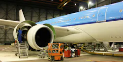 Worker on a ladder servicing an airplane wing
