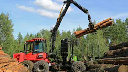 Forestry Machine lifting several logs on a job site